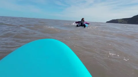 Front of blue surf board moving through water towards surfer Stock Footage 272589863
