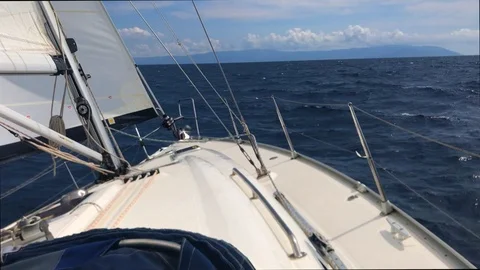 Front bow of a sailboat open sails in the sea waves Stock Footage 112604206
