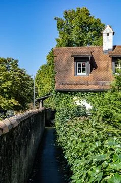 The front of the building with the dormer windows and the white chimney in .. Stock Photos