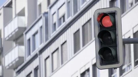 In front of a building, there is a red traffic light clearly visible Stock Footage 304840752