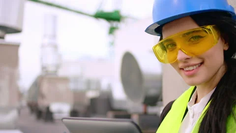 In front of the camera attractive lady engineer smiling large on the roof top of Stock Footage 139824009