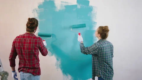 In front of the camera charismatic and funny couple painting the wall in the Stock Footage 171219820