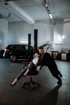 Front of the camera good looking guy playing funny with a customer lady on a Stock Photos