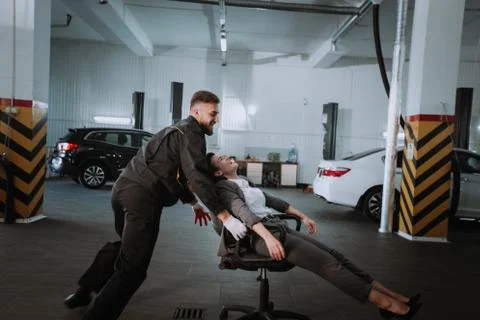 Front of the camera good looking guy playing funny with a customer lady on a Stock Photos