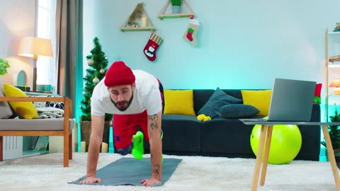 In front of the camera man doing a hard workout at home online he using the Stock Footage 160807360