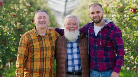 In front of the camera posing old farmer man and his two sons in the middle of Video stock 166564729