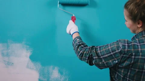 In front of the camera smiling lady working at home painting her wall in the Stock Footage 171224203
