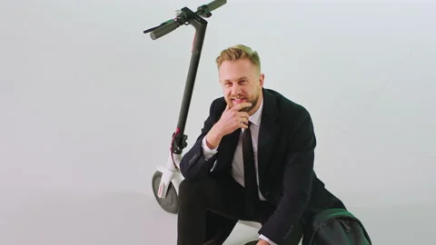 In front of the camera in the studio with white background businessman in a Stock Footage 131558773