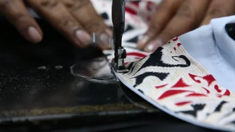 In front of the camera, the tailor uses his professional sewing machine Stock Footage 265934919