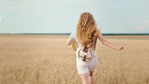 In front of the camera very attractive blonde hair lady country side running Video stock 136248494