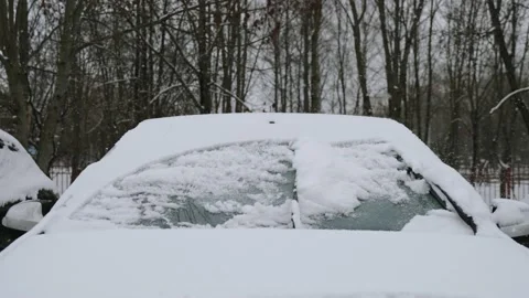 Front of car is covered with snow. Wiper blades clean windshield once. Stock-Footage 225515009