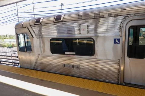 The front car of a silver subway train at an outdoor station Stock Photos