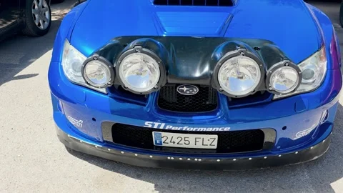 Front close up of a blue Subaru Impreza WRX STi sports car with rally night Stock Footage 337003684