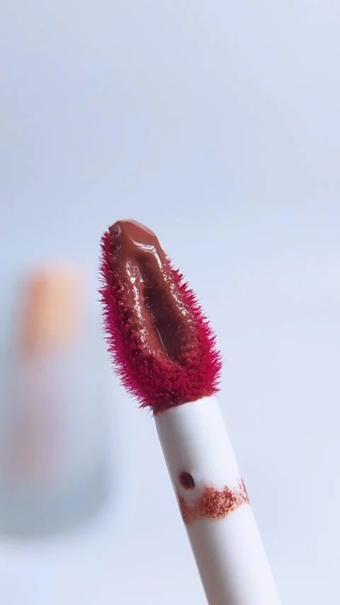 Front close up of red lip tint brush applicator. Isolated on soft blurred w.. Stockbeeldmateriaal 340629405