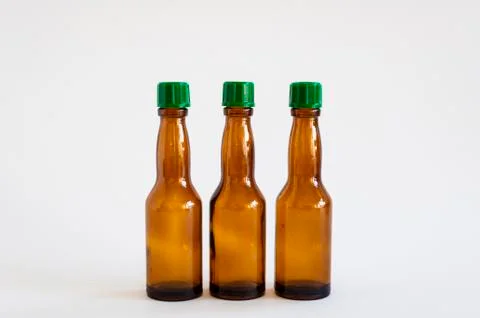 Front close-up shoot of three small alcohol bottles brown colored Stock Photos