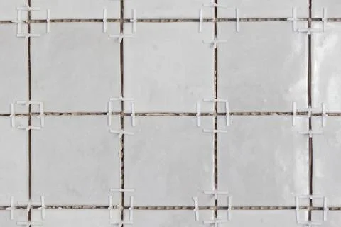 A front close up of a tile wall under construction. The wall is being tiled.. Stock Photos