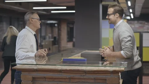 Front desk man doing job very well and cheerfully consulting customer. Stock Footage 125686049
