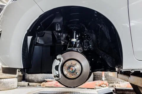 Front disc brake on car in process of new tyre replacement. The rim is remove Stock Photos
