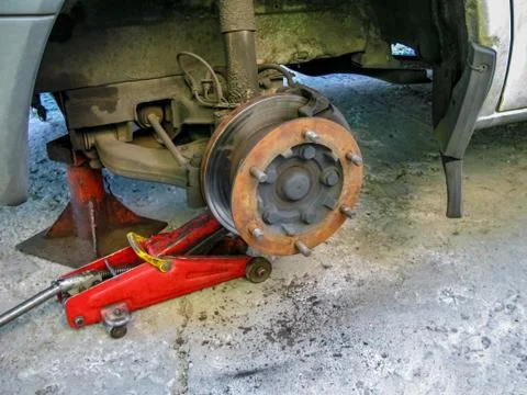 Front disc brake on car in process of new tire replacement. Foto stock