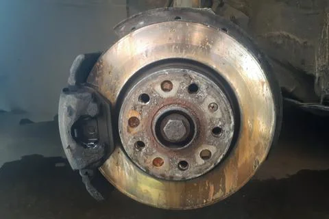 Front disc brake on car in process of new tire replacement. Stock Photos