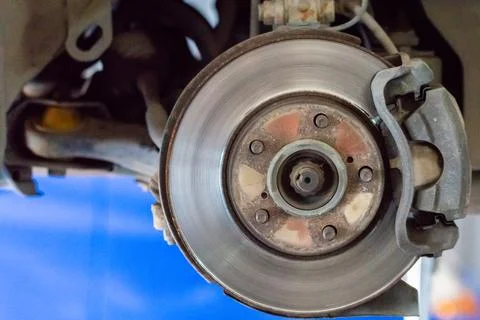 Front disc brake on car in process of service. The rim is removed showing the Stock Photos