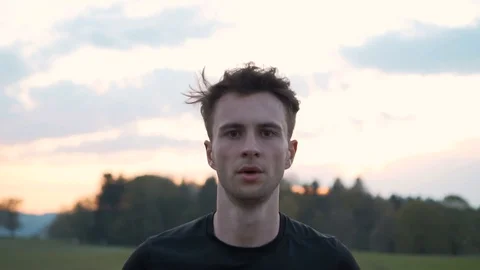Front dolly of man athlete running and looking at camera, slow motion Stock Footage 129611343