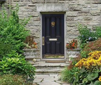 Front door of  house with flagstone path and lush garden Stock Photos