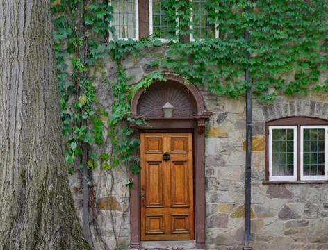 Front door of old stone vine covered house Stock Photos