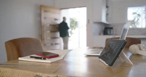 Front door opening man entering placing mug on wooden table, sitting and using Stock Footage 348445985