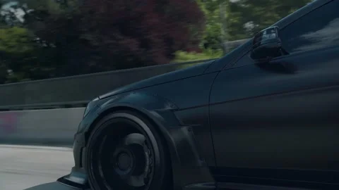 Front drivers side fender on a driving Black Mercedes C63 Video stock 211473940