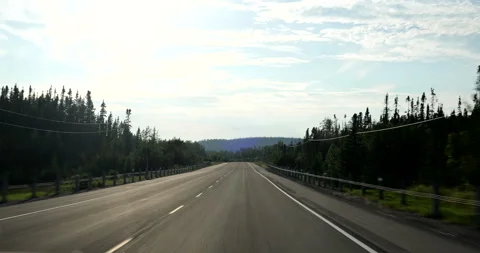 Front driving plate highway through the forest of British Columbia Canada Stock Footage 287489803