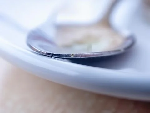 Front edge of a small spoon on a small plate Stock Photos