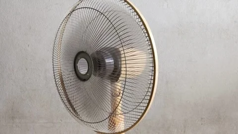 The front of electric table fan is spinning and forth, decreasing heating Stock Footage 300913799