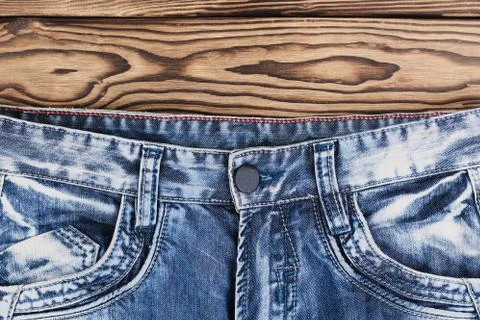 Front empty pockets on new blue jeans on rustic wooden brown planks Stock Photos