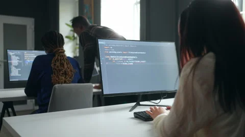 Front-end developer working in office, view on display through shoulder, team of Stock Footage 233724149