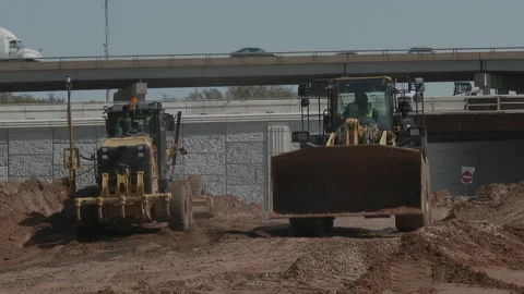 Front end loader and grader work site near Interstate I-35 in background, 4K. Stock Footage 151595211