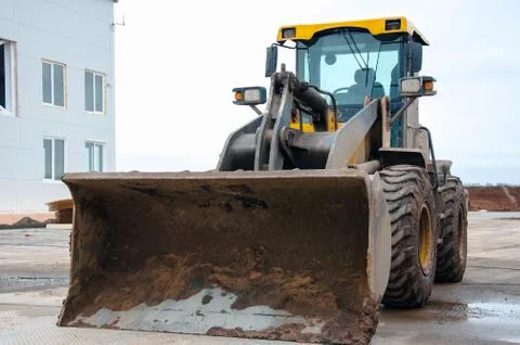 Front-end loader at a construction site. Big loader close-up. Stock Photos