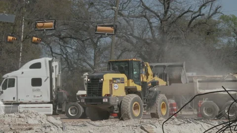 Front end loader dumps broken concrete into waiting truck, 4K. Stock Footage 151591679