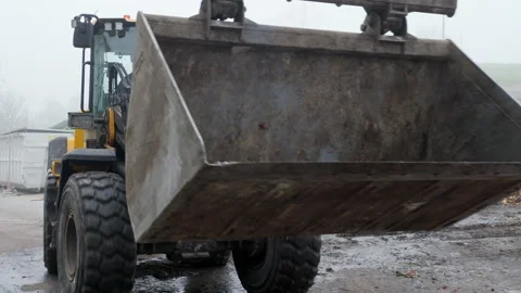 Front end loader moving along recycling center area, close up view Stock Footage 234186365