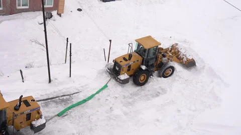 Front End Loader towing out another Front End Wheel Loader, which is deeply Stock Footage 327627687