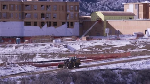 Front End Loader tractor drives through a construction site Stock Footage 229438723