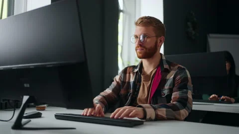 Front-end web developer working in office, sitting at table with computer Stock Footage 233733934