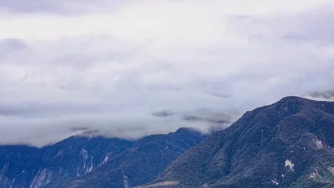 In front of eyes, billowing clouds fly over the continuous mountains Stock Footage 307181658
