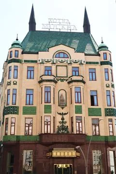 The front facade with many windows and green reliefs and the green roof of th Stock Photos