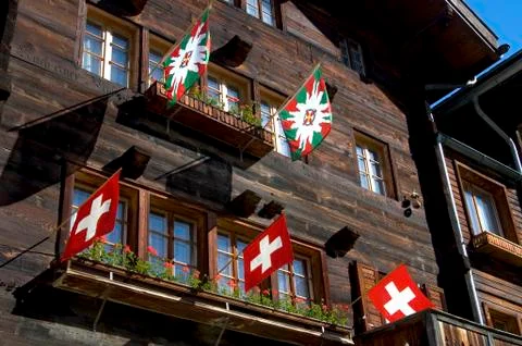 Front face of a chalet decorated with flags wiler valais switzerland Fotos de archivo