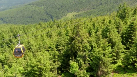 Front-facing aerial pedestal shot of yellow mountain gondola cabin Stock Footage 312593124