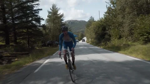 Front-Facing Follow Shot of a Road Cyclist Whizzing Down Empty Roads Amidst.. Stock Footage 287737311