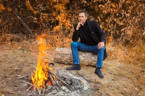 In front of fire is man Stock Photos