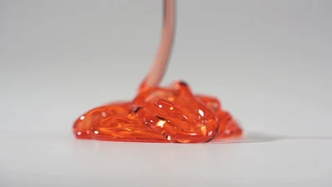 Front Focus: Red thick liquid flowing down on the flatness. 2-x slow motion Stock Footage 123988121