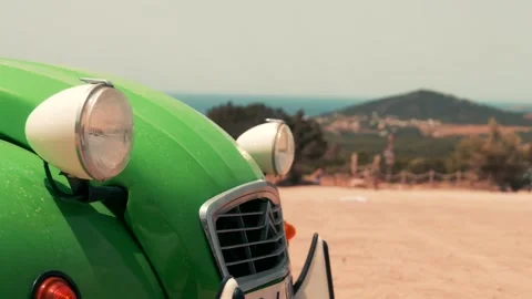 Front of a green old timer, background a hill Stock Footage 229192599